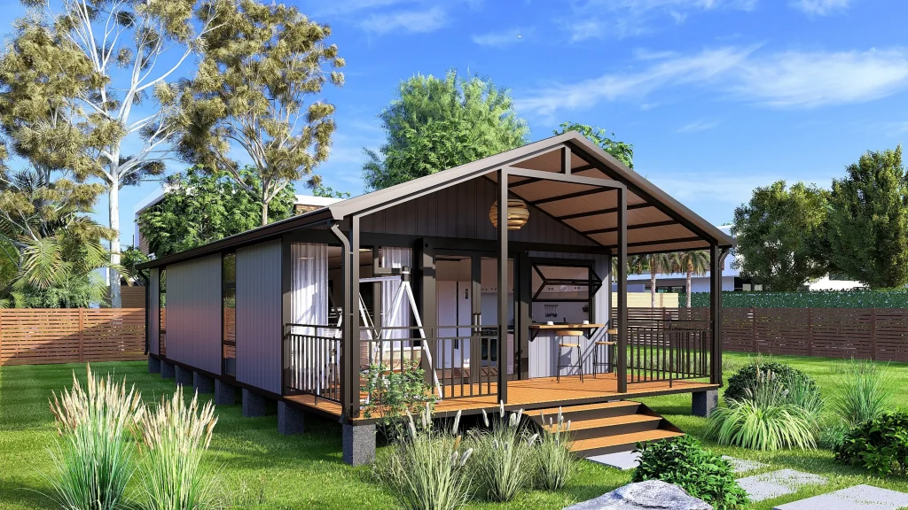 A modern expandable container home with dark metal siding, a pitched roof, and a large wooden deck, set in a sunny suburban backyard.